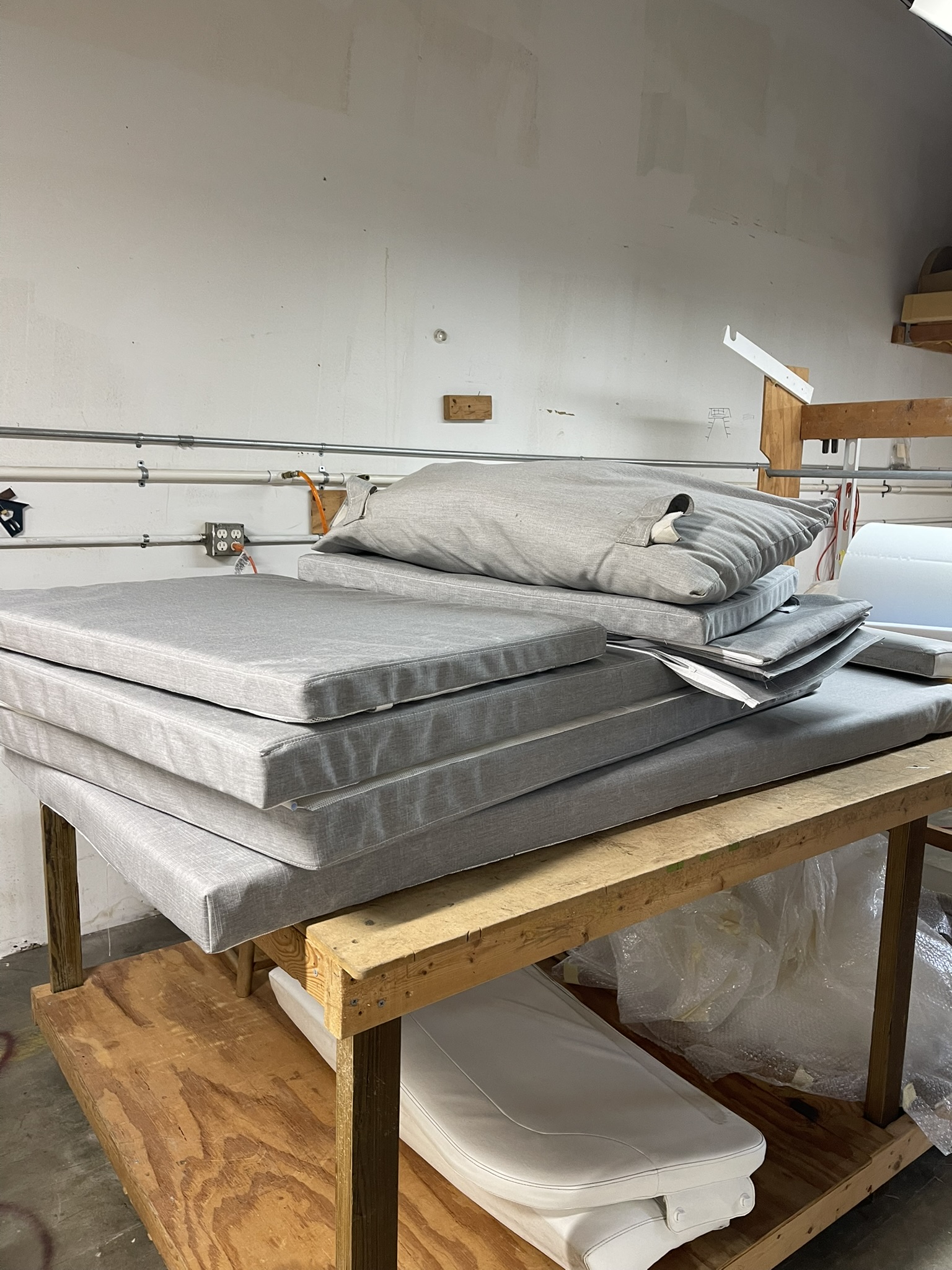 Grey cushions of different shapes on a workshop table